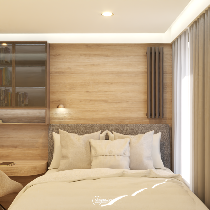 Zdjęcie przedstawia jasne i przestronne wnętrze sypialni. Na pierwszym planie widoczne jest łóżko z białym drewnianym stelażem i ciemnoszarym materacem. Na łóżku znajduje się biała pościel z delikatnym wzorem i miękkie poduszki. Obok łóżka stoi drewniana szafka nocna z lampką. W tle, po prawej stronie łóżka, znajduje się biurko z drewnianym blatem i szufladami. Obok biurka znajduje się wygodne krzesło z brązowym obiciem. Sypialnię zdobią jasne zasłony i białe ściany. Podłoga wyłożona jest drewnianym parkietem. Projekt autrorstwa Pracowni wnętrz oko.na.design